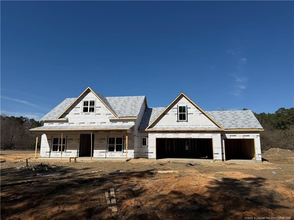 unfinished property featuring driveway, a porch, and an attached garage