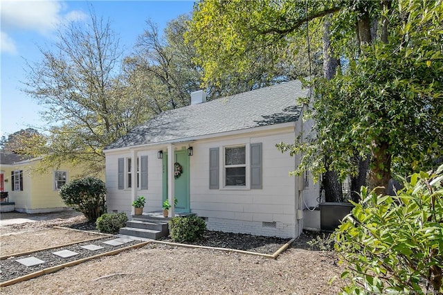 bungalow-style home featuring a shingled roof, crawl space, and a chimney