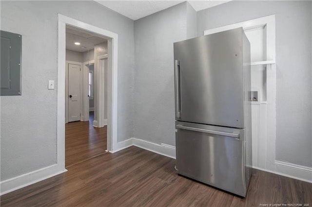 kitchen with electric panel, baseboards, dark wood-style flooring, and freestanding refrigerator