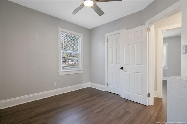 unfurnished bedroom featuring dark wood-style flooring, a closet, a ceiling fan, and baseboards