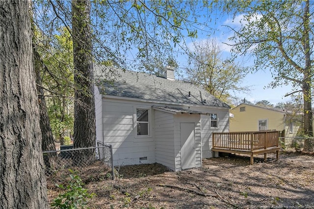 rear view of house featuring a chimney, a shingled roof, crawl space, fence, and a deck