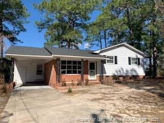 tri-level home featuring a carport, entry steps, and driveway