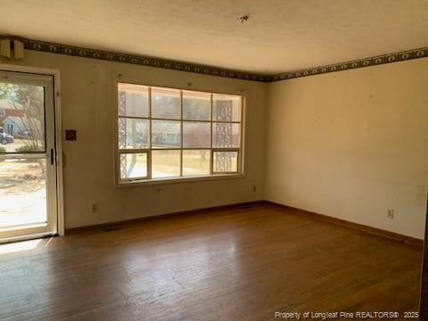 unfurnished room featuring baseboards and wood finished floors