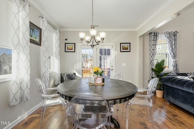 dining space with baseboards, a notable chandelier, ornamental molding, and hardwood / wood-style floors