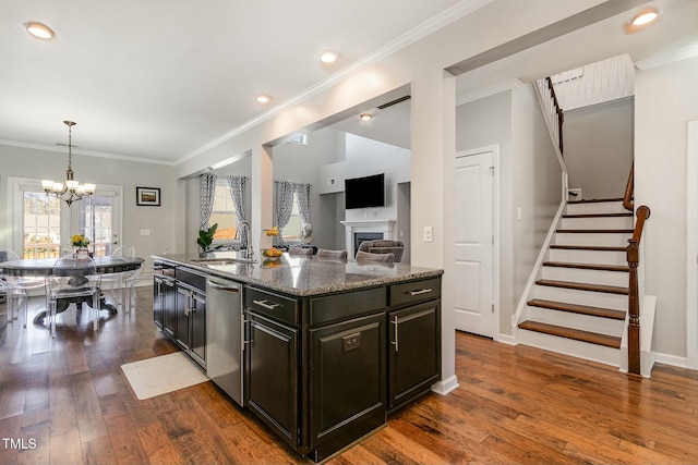 kitchen featuring a sink, stainless steel dishwasher, dark stone countertops, dark wood finished floors, and crown molding