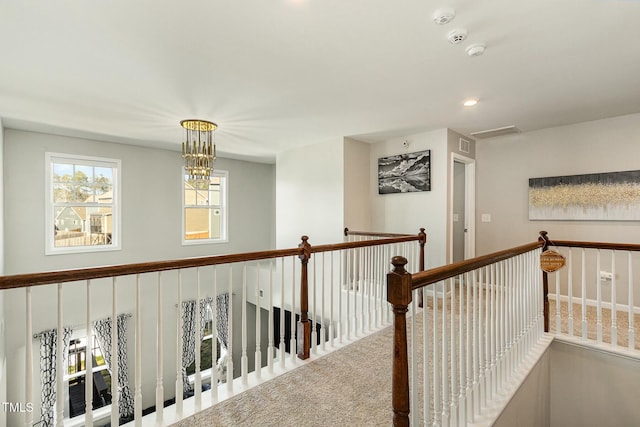 corridor featuring visible vents, an upstairs landing, carpet floors, a chandelier, and recessed lighting