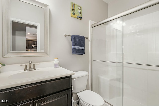 full bath with a stall shower, vanity, and toilet