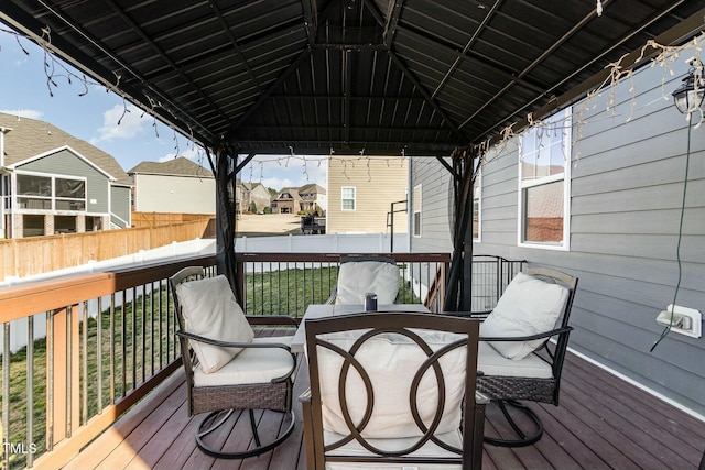 wooden terrace featuring a residential view, fence, and a gazebo