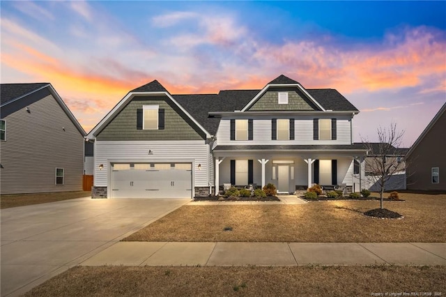 craftsman house with covered porch, driveway, and an attached garage