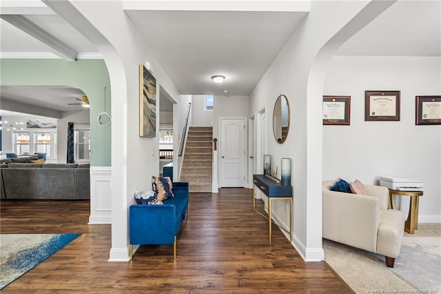 foyer entrance with a healthy amount of sunlight, stairway, arched walkways, and wood finished floors