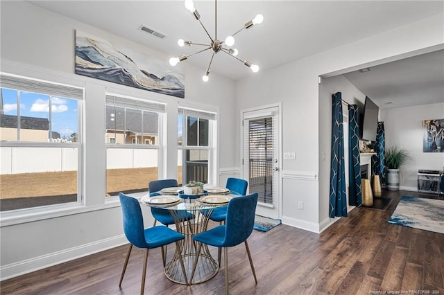 dining room featuring a healthy amount of sunlight, visible vents, an inviting chandelier, and wood finished floors