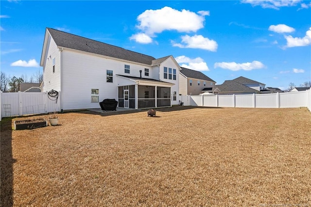 rear view of house with a lawn, a fenced backyard, and a sunroom