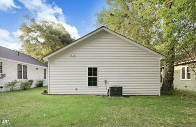 view of side of home with a lawn and cooling unit