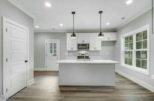 kitchen with recessed lighting, light countertops, stainless steel microwave, white cabinets, and a sink