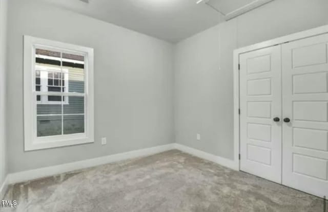 empty room featuring carpet floors and baseboards