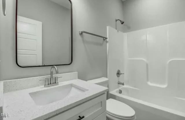 full bathroom featuring bathing tub / shower combination, vanity, and toilet