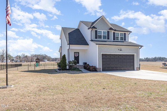 view of front of home with a shingled roof, fence, concrete driveway, and a front yard