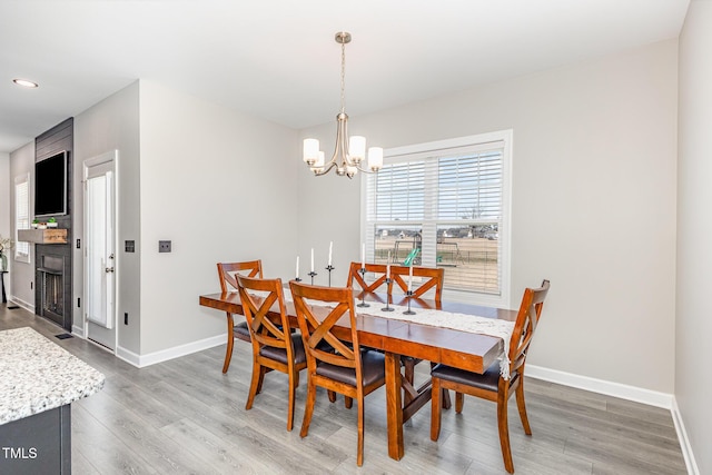 dining space with a chandelier, recessed lighting, wood finished floors, and baseboards