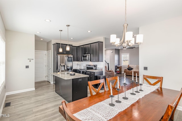 dining space featuring baseboards, visible vents, light wood-style flooring, a notable chandelier, and recessed lighting