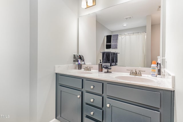 full bath featuring double vanity, visible vents, and a sink