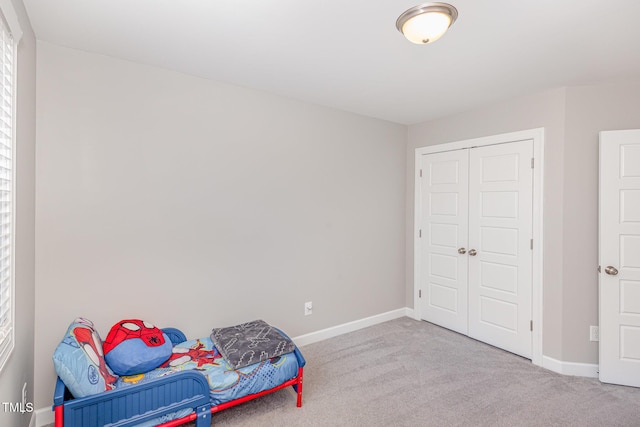 bedroom featuring carpet floors, a closet, and baseboards