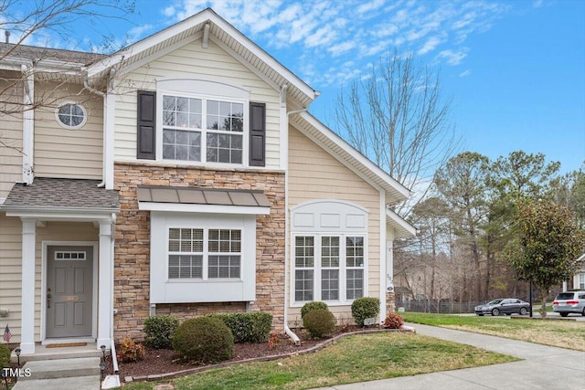 view of front of house with stone siding and a shingled roof