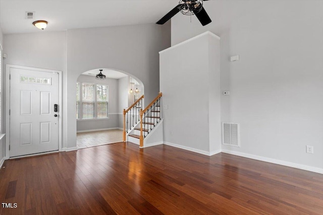 entryway featuring visible vents, arched walkways, wood finished floors, and stairway