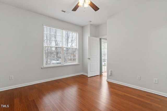 spare room featuring visible vents, ceiling fan, baseboards, and hardwood / wood-style flooring