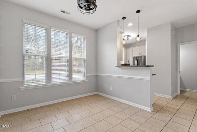 interior space with light tile patterned floors, visible vents, and baseboards