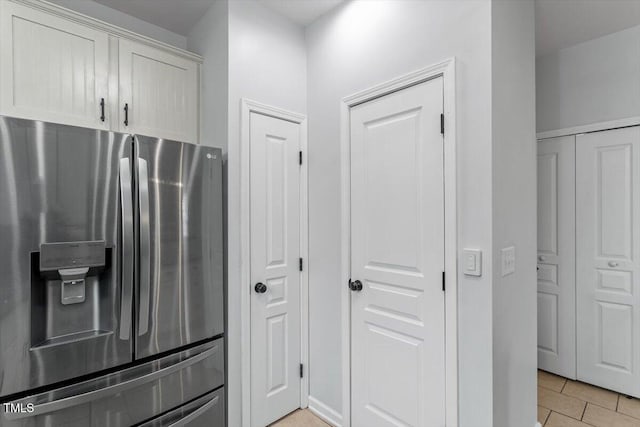 kitchen featuring light tile patterned floors and stainless steel fridge with ice dispenser