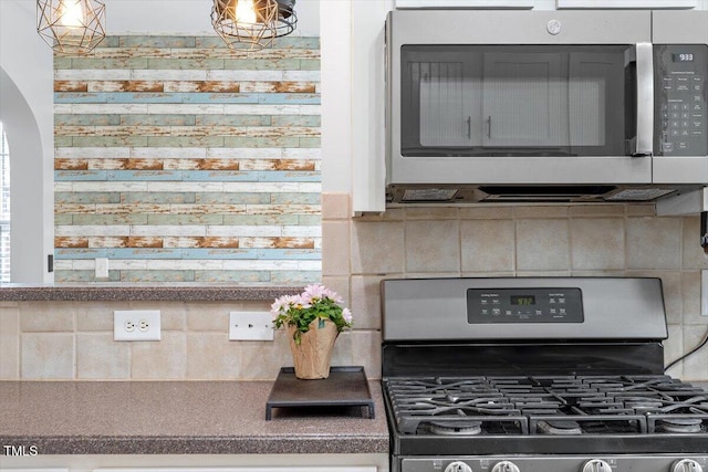 room details featuring decorative backsplash and appliances with stainless steel finishes