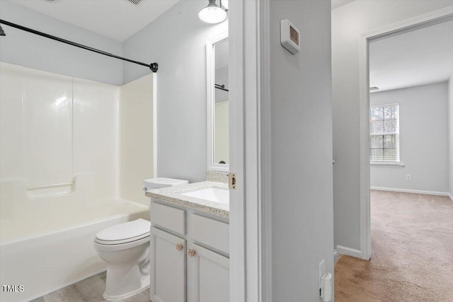 bathroom with vanity, toilet, washtub / shower combination, and baseboards