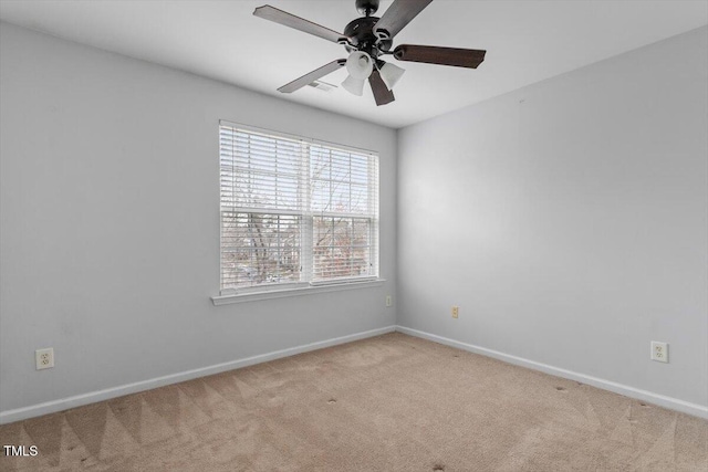 carpeted spare room featuring baseboards and ceiling fan