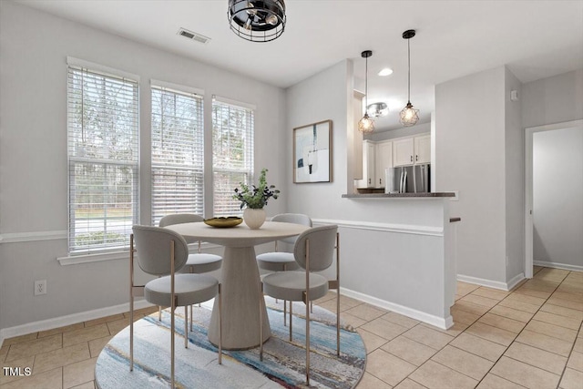 dining space featuring light tile patterned flooring, visible vents, and baseboards