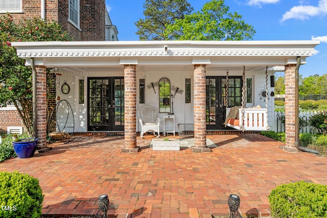 exterior space featuring a porch and french doors