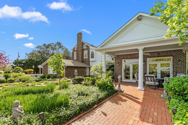 back of house featuring french doors and brick siding