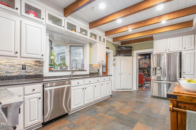 kitchen featuring white cabinetry, beam ceiling, backsplash, and appliances with stainless steel finishes