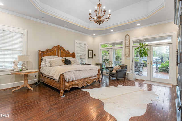 bedroom with an inviting chandelier, hardwood / wood-style floors, access to exterior, a raised ceiling, and french doors