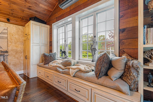 living area with baseboards, vaulted ceiling, a wall mounted air conditioner, dark wood-type flooring, and wood ceiling