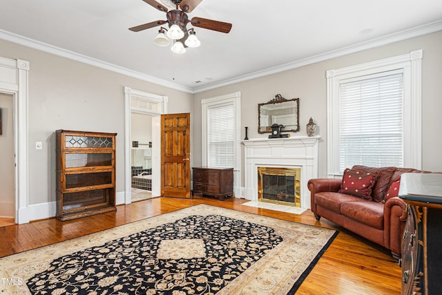 living area featuring light wood-style flooring and crown molding