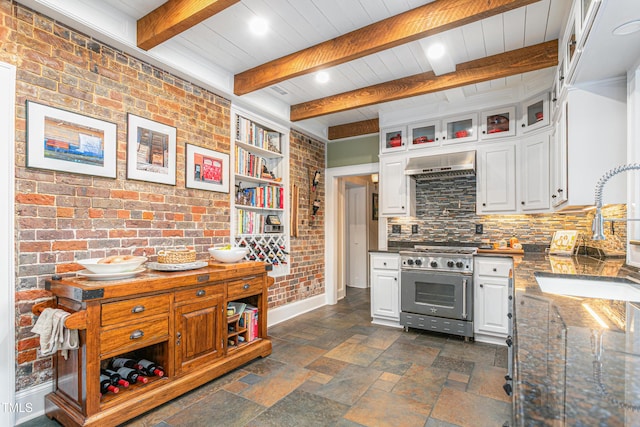kitchen with a sink, white cabinetry, stainless steel range, and extractor fan