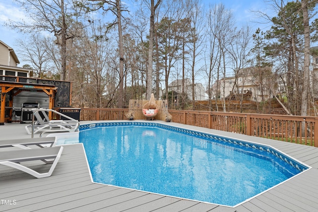 view of swimming pool featuring a fenced in pool, a wooden deck, and fence