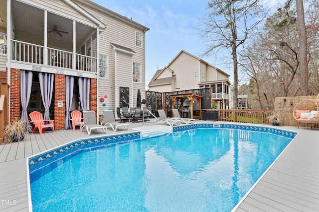 view of pool with a deck, a fenced in pool, and ceiling fan