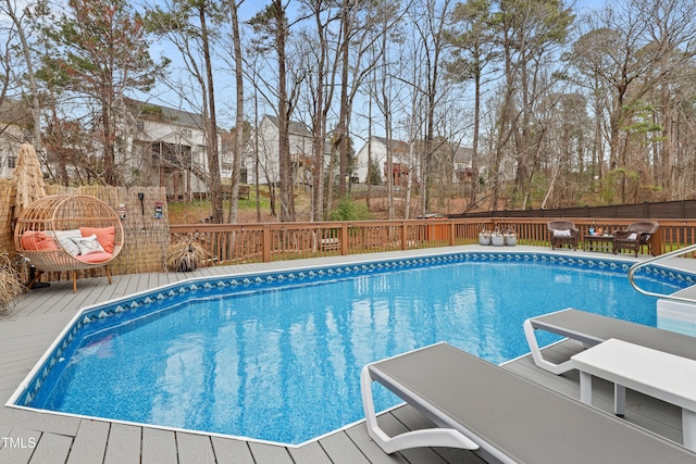 view of swimming pool featuring a fenced in pool, fence, and a wooden deck