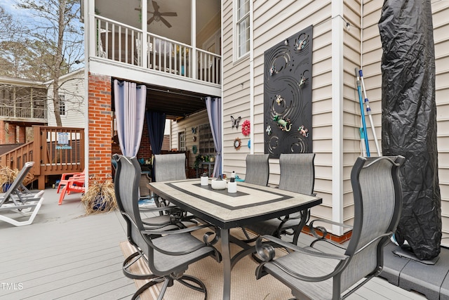 wooden deck featuring outdoor dining area and ceiling fan