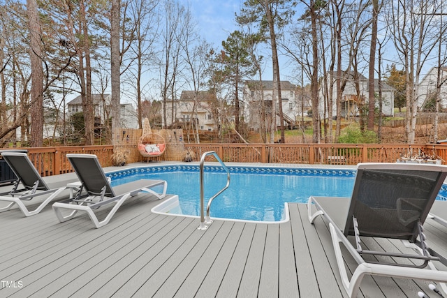 view of swimming pool with fence, a fenced in pool, a residential view, and a wooden deck