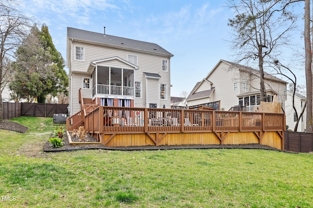 back of property with fence private yard, stairs, a lawn, a deck, and a sunroom