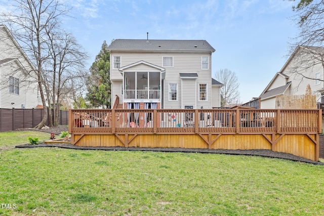 rear view of house featuring a yard, a wooden deck, a fenced backyard, and a sunroom