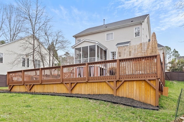 rear view of property featuring a deck, a yard, and a sunroom