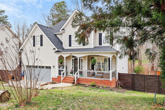 traditional home with driveway, a porch, fence, a front yard, and a shingled roof